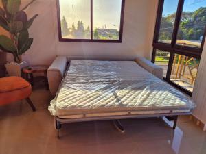 a bed sitting in a room with two windows at Aparta Luxe Penonomé in Llano Marín