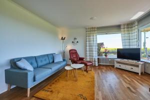 a living room with a blue couch and a tv at Strandbrise in Fehmarn