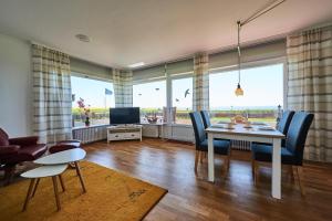 a living room with a table and chairs and a television at Strandbrise in Fehmarn