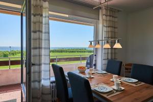 a dining room with a table and a large window at Strandbrise in Fehmarn