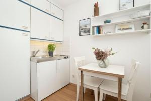 a small kitchen with a table and a sink at Strandhotel Scharbeutz Kleine Krabbe in Scharbeutz
