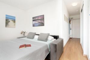 a white bedroom with a bed with a red tray on it at Strandhotel Scharbeutz Kleine Krabbe in Scharbeutz