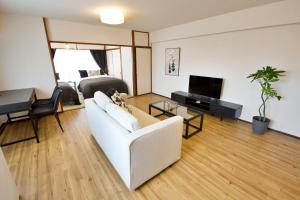 Una sala de estar con un sofá blanco y un televisor. en 寛永寺坂ハイム 803 東京観光の拠点に最適 鶯谷駅2分, en Tokio