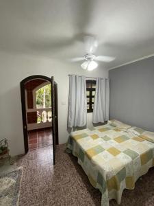 Un dormitorio con una cama y un ventilador de techo. en Recanto Dom José, en Peruíbe 11 fotos más