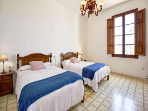 a bedroom with two beds and a chandelier at Holiday Home in Migjorn with Private Pool in Llucmajor +28 photos