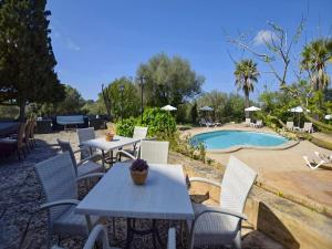 a group of tables and chairs next to a pool at Holiday Home in Migjorn with Private Pool in Llucmajor