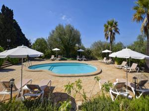 a swimming pool with chairs and umbrellas at Holiday Home in Migjorn with Private Pool in Llucmajor