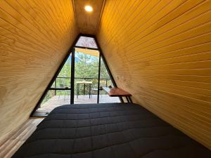 a room with a bed and a large window at Cabina con terraza vista al río en Roca Truful in Melipeuco