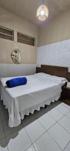 a bedroom with a large bed with a blue pillow at Pousada Casa do Peregrino in Pesqueira