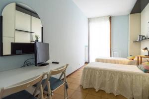 una camera con scrivania, TV e letto di Duomo 15 minuti a Milano
