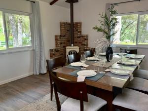 a dining room with a table and chairs and windows at The Happy Cabin w/ hot tub in Oakhurst +24 photos