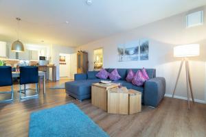 a living room with a blue couch and a table at Brenkenhagener Weg 8-10 Calimera in Körnick