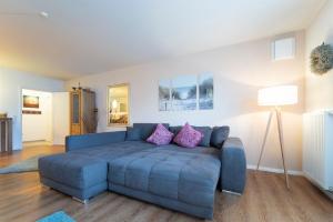 a living room with a blue couch with purple pillows at Brenkenhagener Weg 8-10 Calimera in Körnick +41 photos