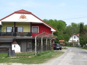 una casa rossa e bianca sul ciglio di una strada di Atera a Banovci