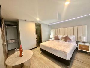 a bedroom with a bed and a table with wine glasses at Hotel Agora Boutique in Bogotá +5 photos
