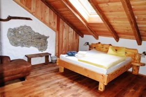 ein Schlafzimmer mit einem Bett und einem Stuhl in einem Zimmer in der Unterkunft Wohlfühloase Koglerhof in Friesach