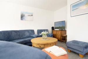 un salon avec un canapé et une table dans l'établissement Ferienhaus Nachtmann, à Kellenhusen