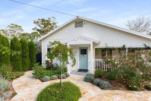 una casa bianca con una porta blu di Cherry Cottage Bowral a Bowral