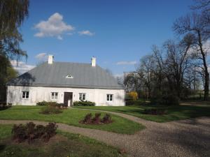 a white house with a gray roof and a garden at Dwór Udrycze in Udrycze