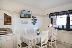 a dining room with a table and white chairs at Ostseestern in Grömitz