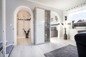 a white living room with a glass door at Ostseestern in Grömitz