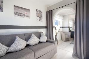 a living room with a gray couch with pillows at Ostseestern in Grömitz +37 photos