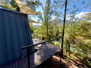 梅利佩乌科Cabina vista al río en Roca Truful的房屋一侧的木甲板上配有桌子