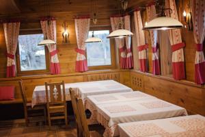 uma sala de jantar com duas mesas e duas janelas em Samedru em Măgura