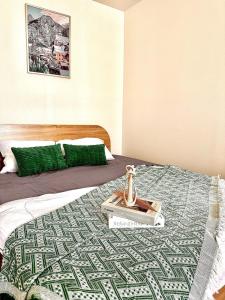 Una cama con un libro y un jarrón encima. en CinCin Popular Condo, en Thung Si Kan
