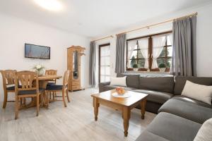 ein Wohnzimmer mit einer Couch und einem Tisch in der Unterkunft Ostseegarten Goldulme in Kellenhusen