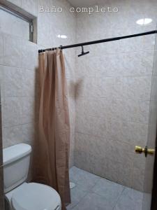 a bathroom with a toilet and a shower curtain at Trabajo, Negocios o Placer hospedate con nosotros in Aguascalientes