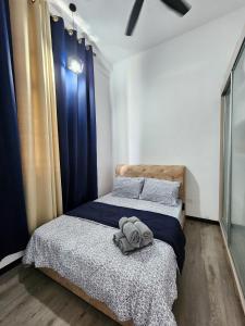 a bedroom with two beds with blue curtains at Urban Nook by MySky Stays at Presint 5 Putrajaya in Putrajaya