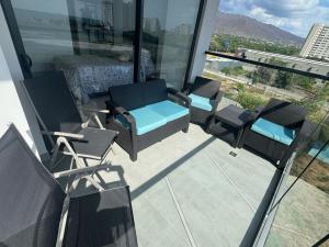 a balcony with chairs and furniture on a building at Espectacular Apartamento en Santa Marta in Playa Bello Horizonte
