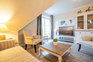 ein Wohnzimmer mit Sofa und Fernseher in der Unterkunft Muschelbank in Scharbeutz
