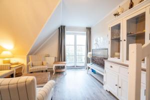ein Wohnzimmer mit Sofa und Fernseher in der Unterkunft Muschelbank in Scharbeutz