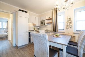 eine Küche und ein Esszimmer mit Tisch und Stühlen in der Unterkunft Muschelbank in Scharbeutz