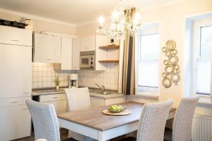 eine Küche mit Esstisch und Stühlen in der Unterkunft Muschelbank in Scharbeutz