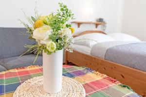 沙博伊茨Fahrenkrug Westbrise的白色花瓶,桌子上放着一束鲜花