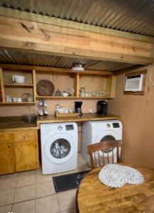 een keuken met een wasmachine en een tafel bij Shady Pine Cabin in Benton