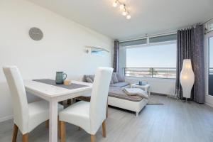 ダーメにあるStrandhotel Dahme TraumMeerBlickのテーブルと椅子とソファのあるダイニングルーム