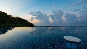 a pool of water with a table in the middle at Glamday Style Okinawa Yomitan Hotel & Resort in Yomitan