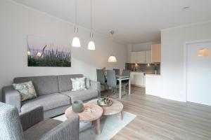 a living room with a couch and a table at Seepark Strandglück in Scharbeutz