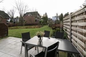 a patio with a table with a vase of flowers on it at Seepark Strandglück in Scharbeutz +27 photos