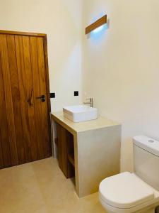 a bathroom with a white toilet and a sink at Villa Achado in Santa Maria