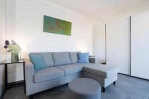 una sala de estar con un sofá y un taburete en Haus Alouette, en Dahme