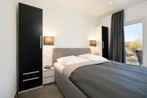 Un dormitorio con una cama grande y una ventana. en Haus Alouette, en Dahme
