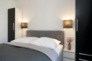 Un dormitorio con una cama con dos lámparas encima. en Haus Alouette, en Dahme