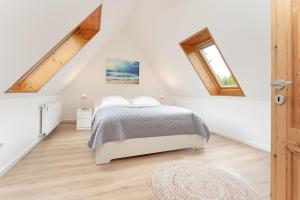 a white bedroom with a bed and a window at Steenkamp 32 Aus-Zeit in Timmendorfer Strand