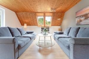 a living room with blue couches and a table at Steenkamp 32 Aus-Zeit in Timmendorfer Strand