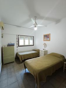 a bedroom with two beds and a ceiling fan at Casa Forum in Santiago del Estero